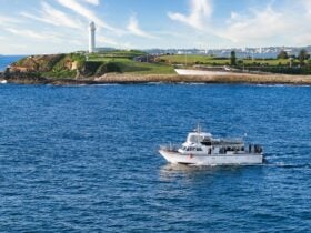 A vessel leaving Wollongong Harbour with the lighthouse in the background