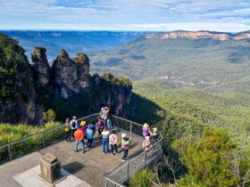 A group of visitors admiring the view of the Three Sisters and Jamison Valley at Echo Point