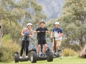 Three people riding electric segways at Lake Crackenback Resort