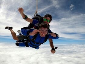 Tandem Skydive between two layers of cloud. Young male instructor and passenger. Big smiles!