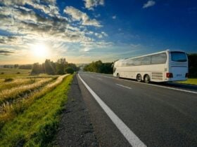 Image of a bus on a road with the sunset in the background