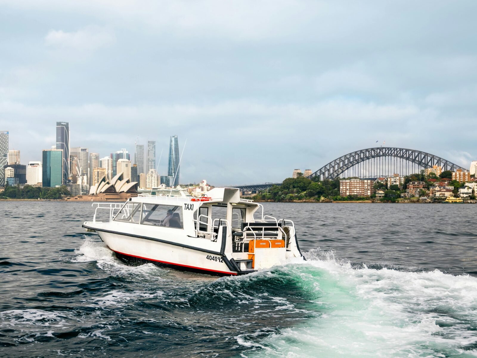 Water taxi on Sydney Harbour travelling along the Harbour with the city scape in the background.