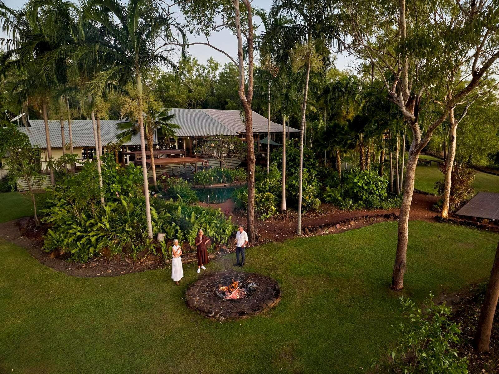 People standing around the fire on the lawn at Seven Spirit Bay