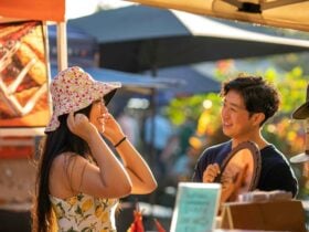 Couple shopping together trying on a hat at the Parap Markets in Darwin