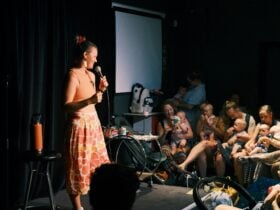 female comedian with babies in audience