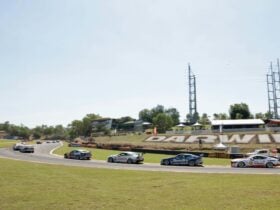 Supercars on track with Darwin sign in background