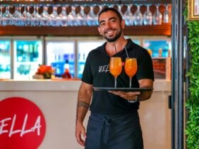 Staff member carrying tropical cocktails.