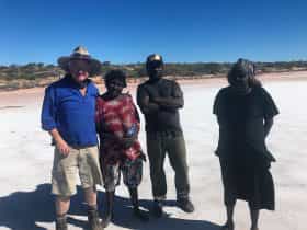 Pintubi Nine First Nation people posing for a photo on a salt lake