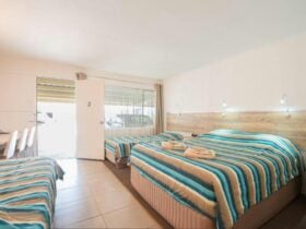 Tripple queen room with blue and pink bed cover, terracotta tiles