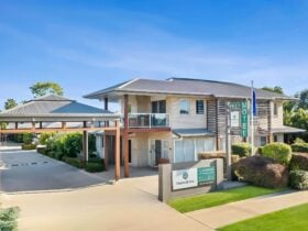 The modern exterior of the Emerald Inn motel with well maintained gardens & grounds.