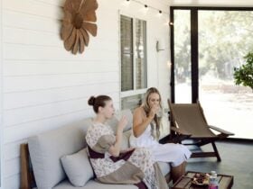 Two women enjoying drinks on the Grapeview Cottage verandah with a Desert Oasis gin grazing tray.