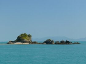 Full view of the small and rocky Henning island with a stretch of sand on the left side