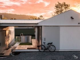 Rail Trail Refuge accom with plunge pool in the background & bike leaning at front at sunrise