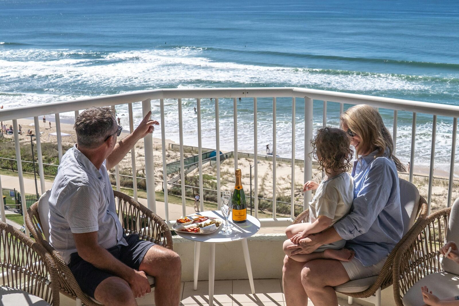 Family sitting on balcony overlooking the ocean