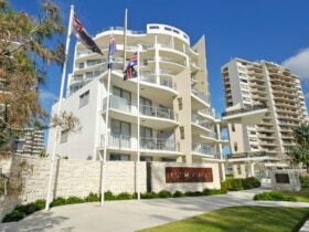 10-story elegant building with sandstone features, clear blue sky, and stunning ocean views