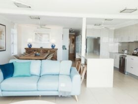 alt text=view of lounge through other kitchen and dining