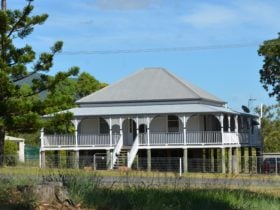 photo of an old Queensland style house with front stairs leading to a verandah across the house