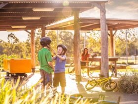 Family resting under shelter during bike ride.