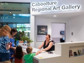 Family interacting with Caboolture Regional Art Gallery team at front desk