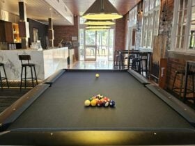 9" American Pool Table with midnight blue felt. 8 Ball pool balls set up ready for a game.