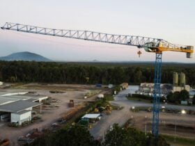 A large tower crane sits above the sunshine coast skyline