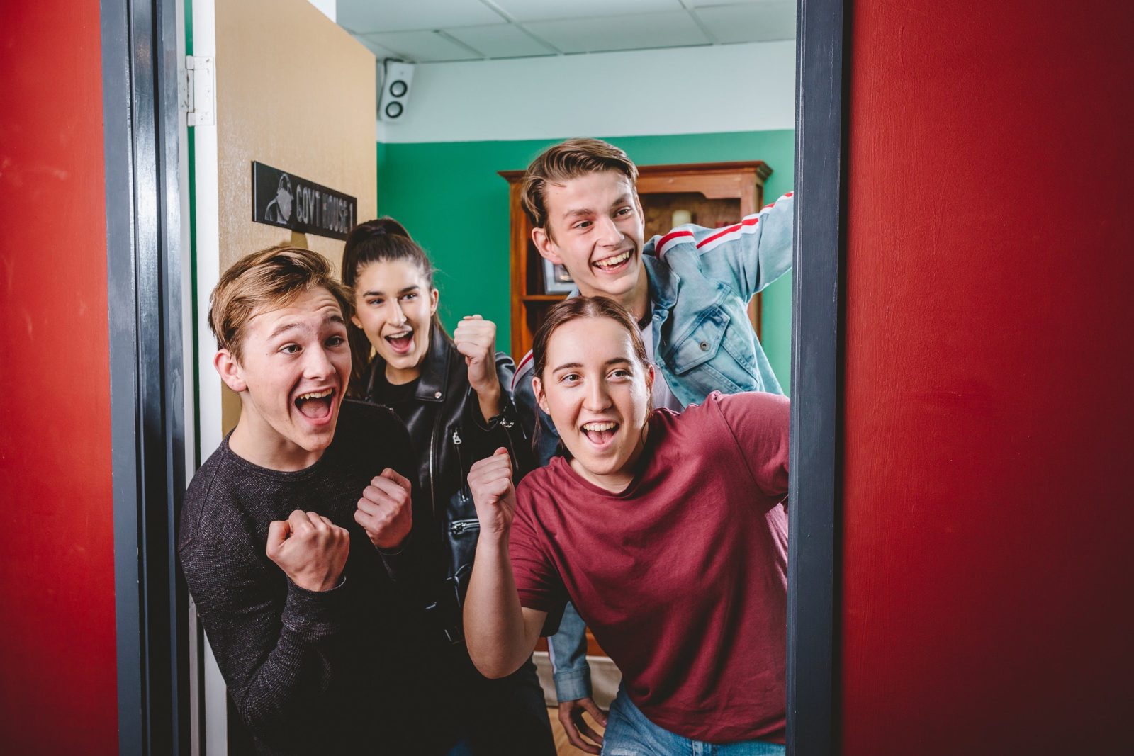 Group of 4 cheering as they break out of the escape room