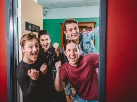 Group of 4 cheering as they break out of the escape room