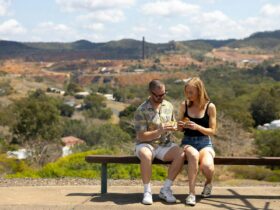 Young man and woman enjoying a meat pie at a lookout at Mount Morgan