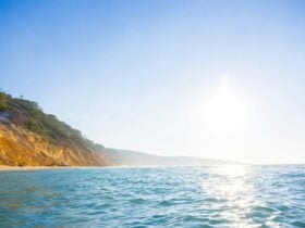 The reflection of the sun on the water with the sandy clips
