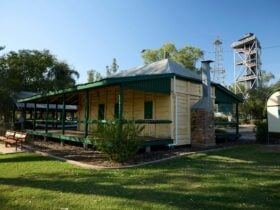 Exterior shot of a white wooden building with green trim