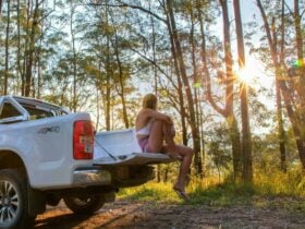 Woman sitting on the back of a 4x4 watching the sunset in Mount Mee Forest Reserve