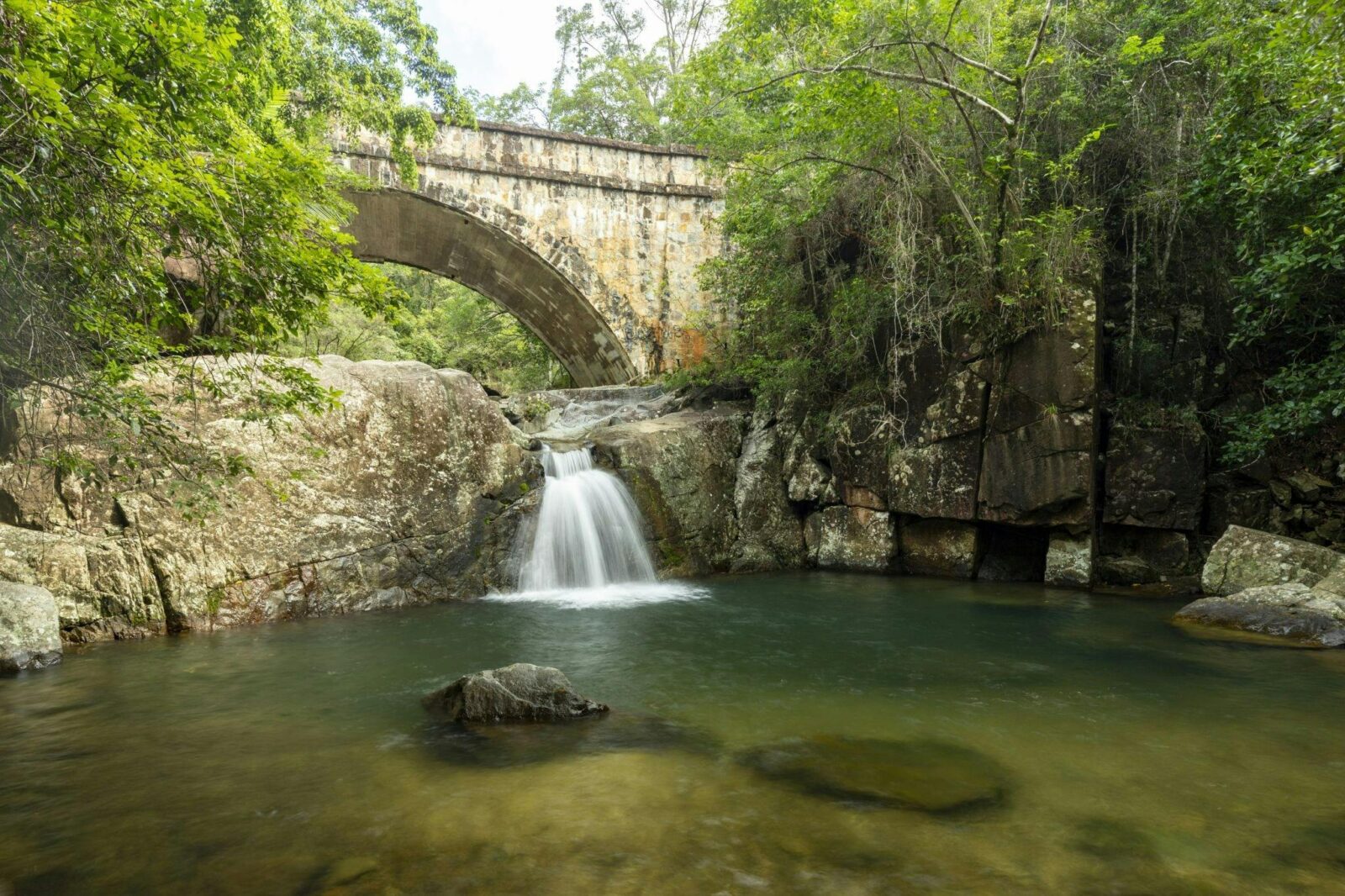 Stone bridge over a little waterfall.