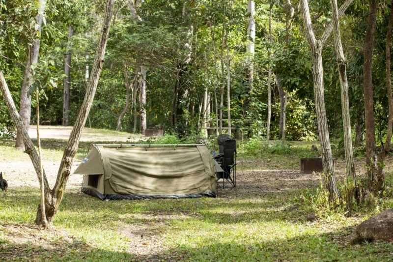 Swag tent pitched beside two camp chairs.
