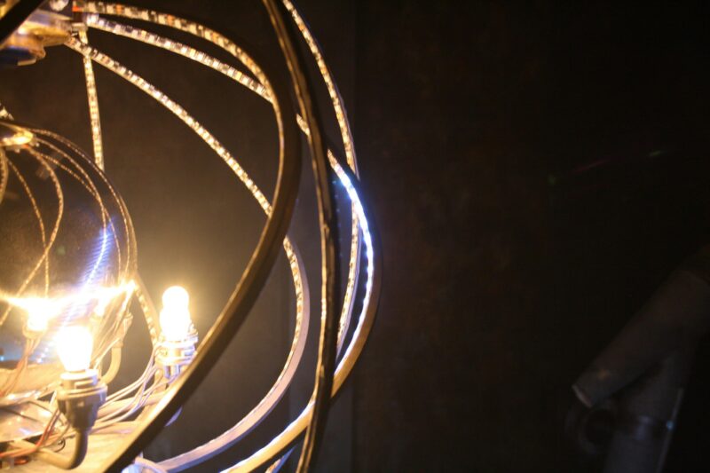 A black background with a glowing illuminated mirror ball and radiation shielding around it.