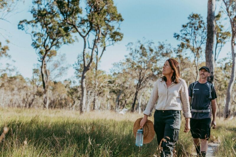 Woman and man walking through scenic bushland trails at Redlands Track Park, Redlands Coast, QLD