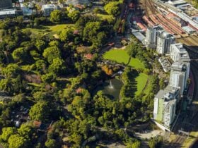 Aerial view of Roma Street Parkland showing dense green spaces of trees and lawn and a lake