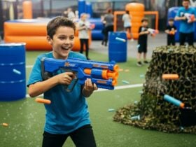 Child shooting Nerf bullets with people in background