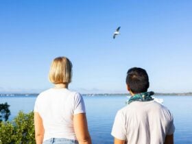 A couple looking up at the sky at a bird at Tin Can Bay