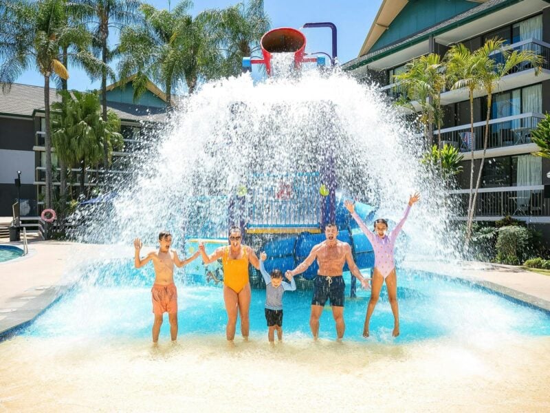 Family standing under the bucket of the junior waterpark at Paradise Resort Gold Coast
