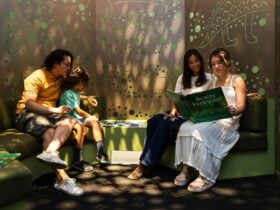 A family reads together in an illuminated space with shadows and lights with a night time feeling