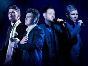 Performers in Celtic Thunder pictured in formal suits and singing into microphones