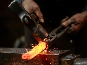 Hammer striking heated metal on anvil.