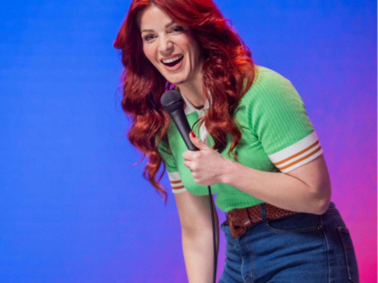 Bron with long auburn hair green shirt and jeans laughing