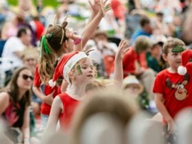 Kids in Christmas outfits dancing in a crowd