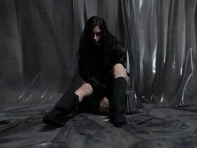 Clara La San sitting on a stool