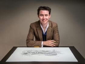 Brodie sitting at a table with a piece of calligraphy in front of him