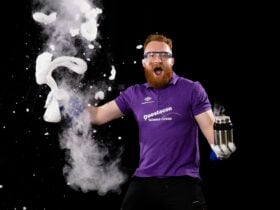 Questacon presenter holds a flask of bubbling liquid nitrogen bubbles.