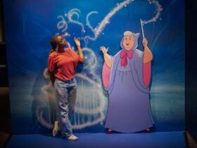 Person standing next to animated character display