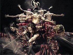 human pyramid of 9 strong athletic men and women dressed in Japanese kimonos and hakama pants