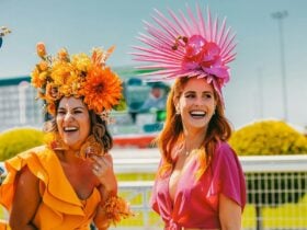 Ladies in Orange and Pink laughing at Racecourse
